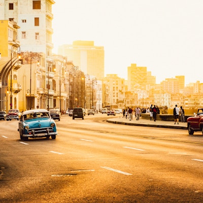 Trafikk ved Malecon-veien, Havanna, Cuba, Latin-Amerika ved solnedgang. Malecon (Avenida de Maceo) er 8 km fra Havana Harbor i Gamle Havana og slutter ved Vedado.